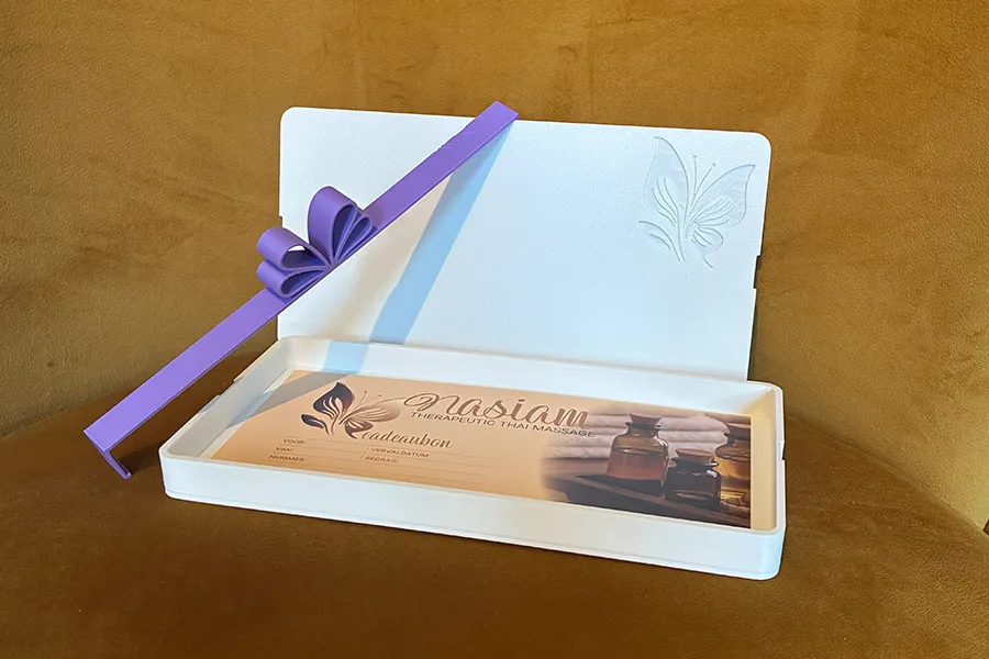 Open gift box with voucher secured by ribbon Open gift box with voucher secured by ribbon